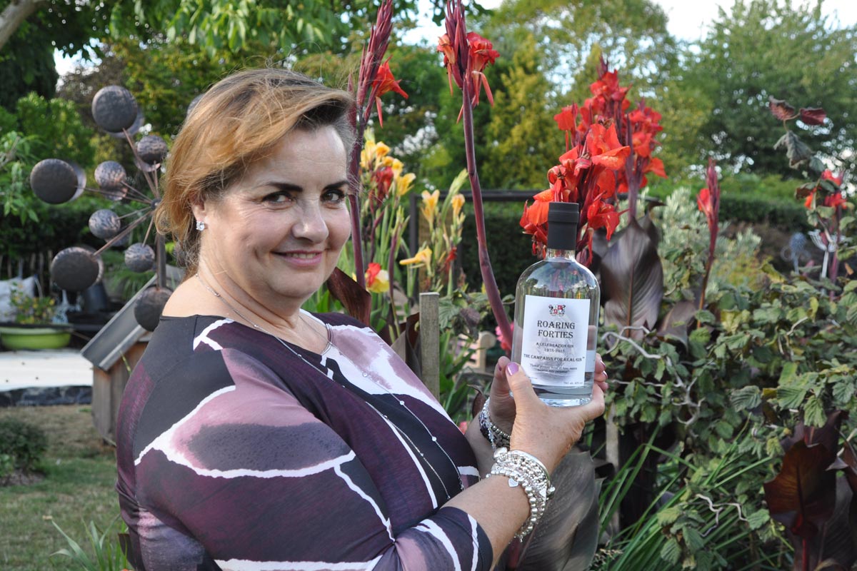Lynne Gibson with bottle of Roaring Forties gin